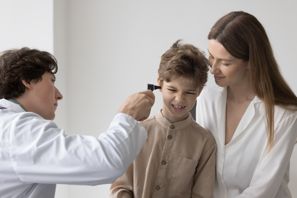 A young boy getting an ear infection diagnosis from the doctor.