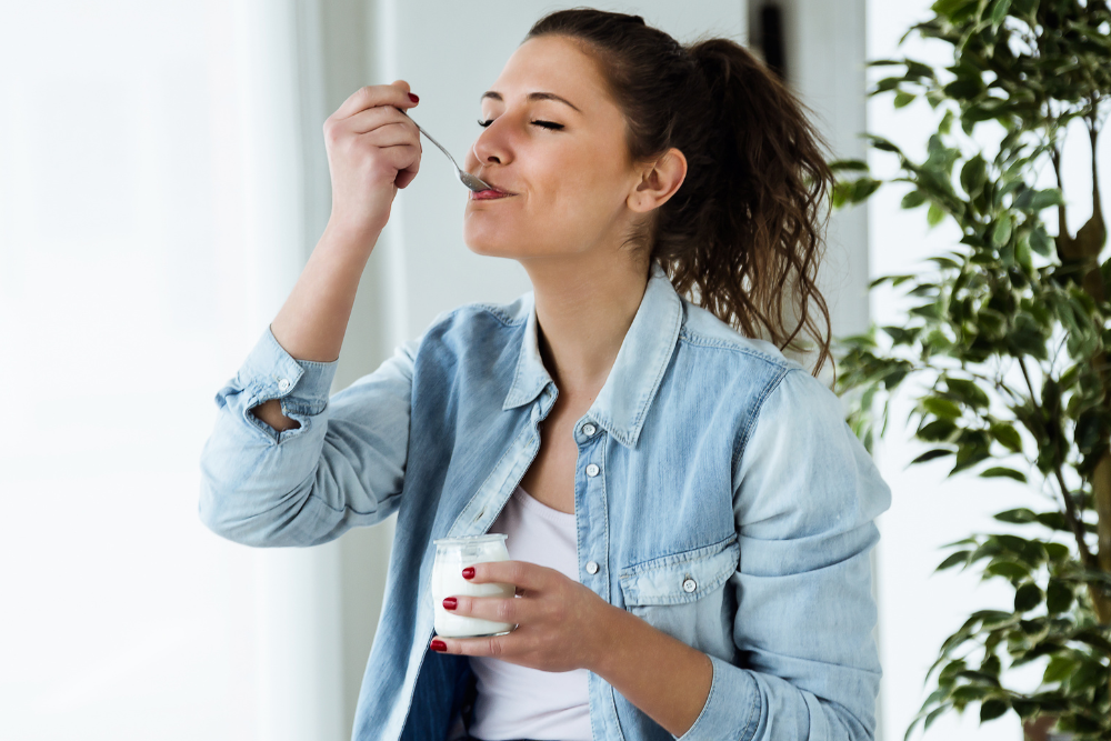 Woman eating yoghurt to relieve thrush