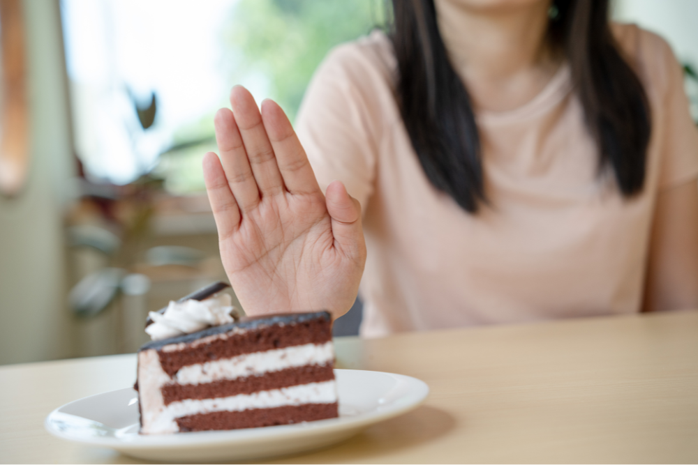 A woman avoiding cake as part of her elimination diet for eczema.