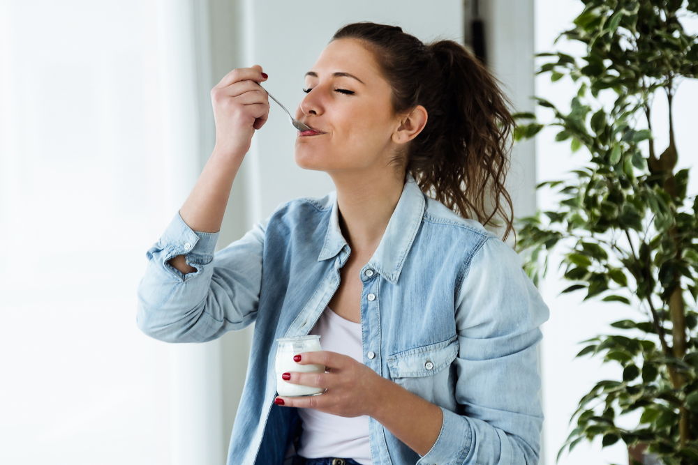 Woman eating probiotic yoghurt to prevent utis.